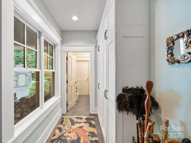 a view of a hallway to a livingroom with wooden floor and a shower