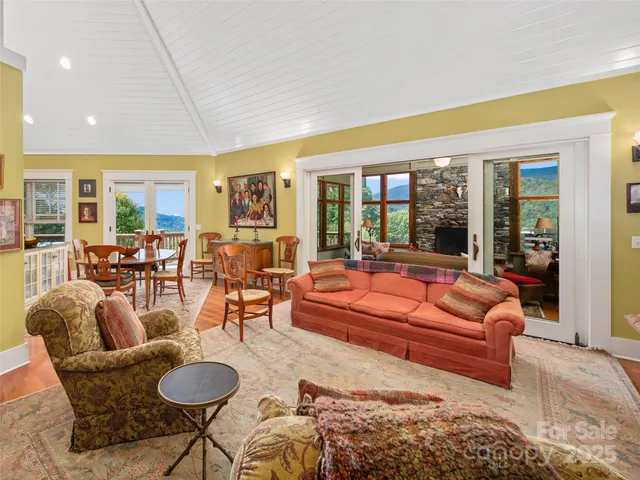 a living room with furniture kitchen view and a large window