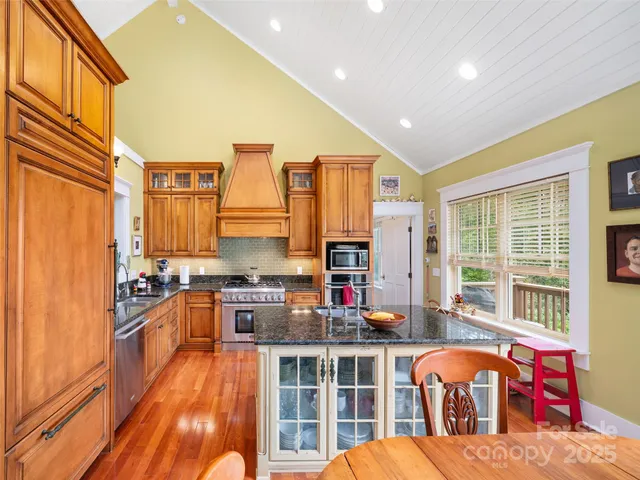 a kitchen with stainless steel appliances granite countertop a stove and a refrigerator