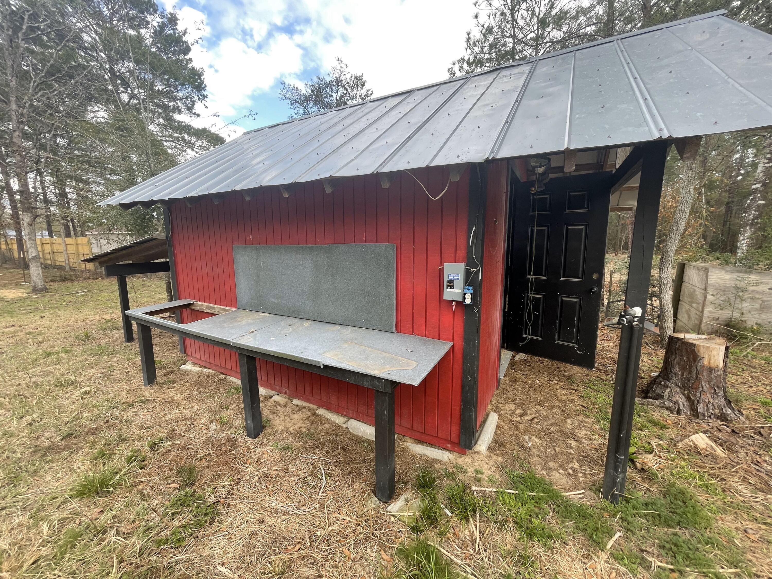 4052 Randi Road Crestview, FL 32539 - Photo 22 of 27 a backyard of a house with barbeque oven table and chairs