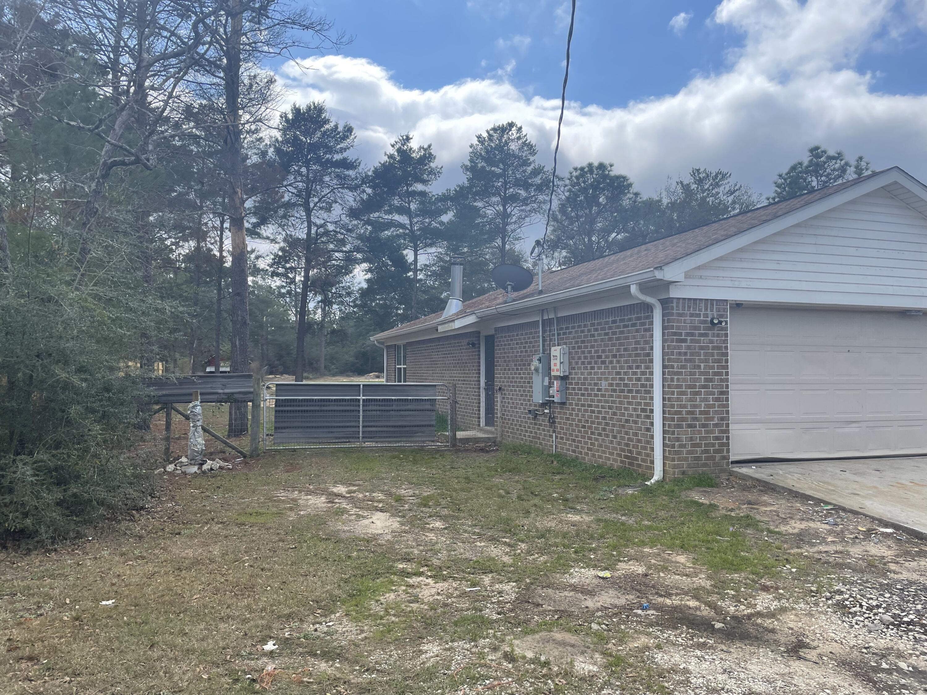 4052 Randi Road Crestview, FL 32539 - Photo 25 of 27 a view of a house with a yard and garage