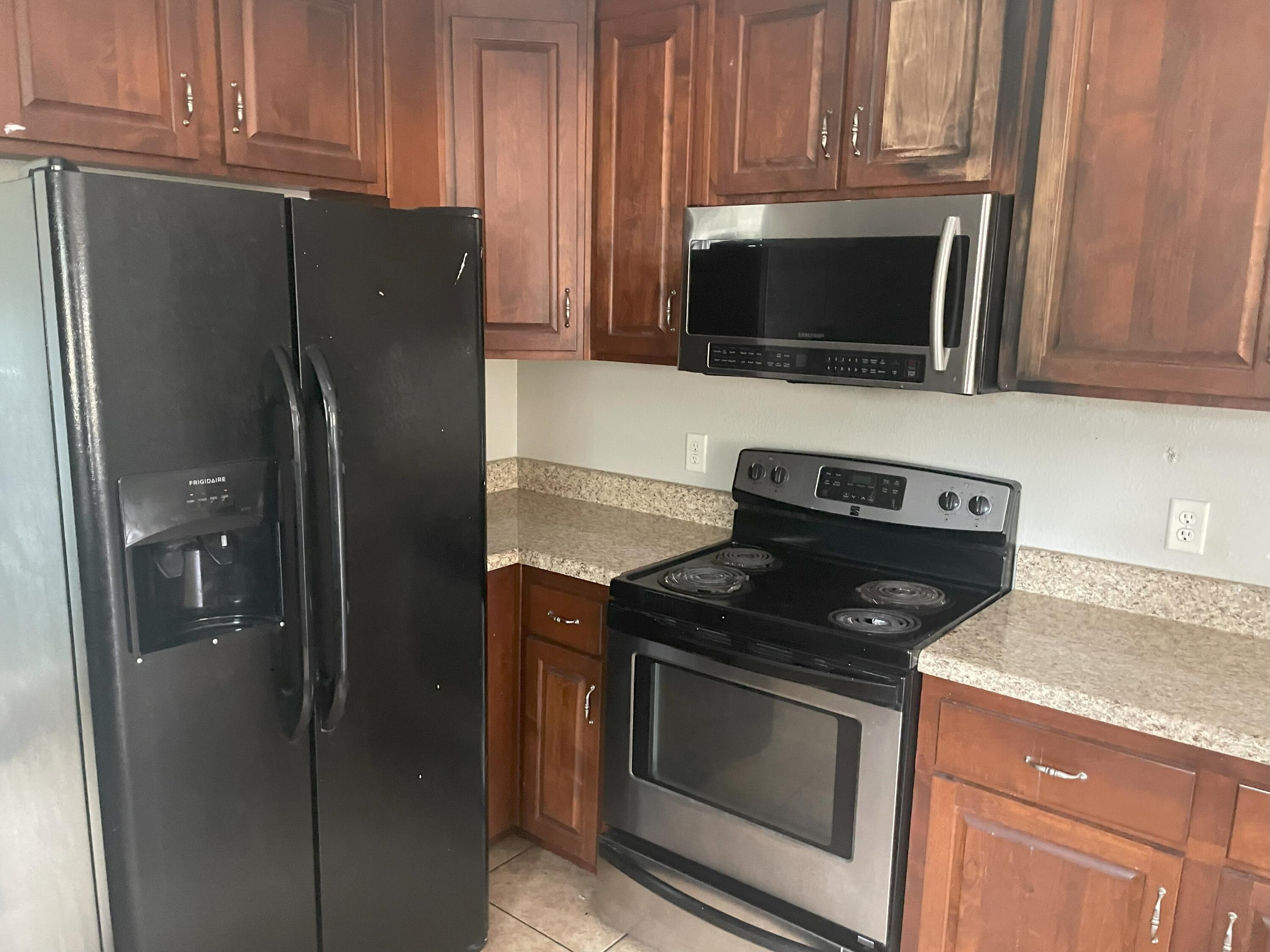 4052 Randi Road Crestview, FL 32539 - Photo 10 of 27 a kitchen with stainless steel appliances granite countertop a refrigerator stove and microwave