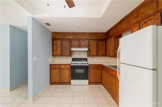 a kitchen with a stove a refrigerator and a sink