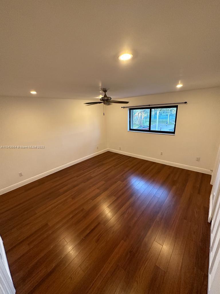 Snapper Creek Townhouses Miami, FL 33173 - Photo 12 of 22 an empty room with wooden floor and windows