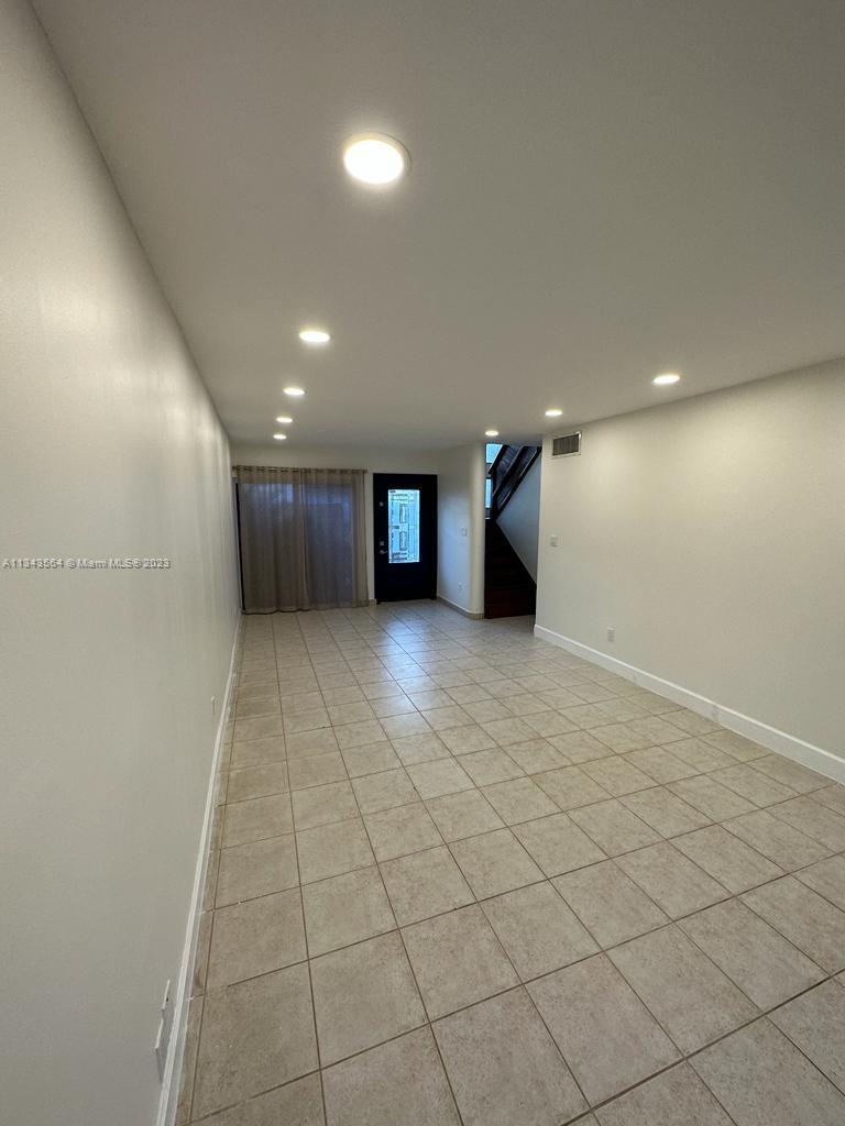 Snapper Creek Townhouses Miami, FL 33173 - Photo 5 of 22 an empty room with a projector and wooden cabinets