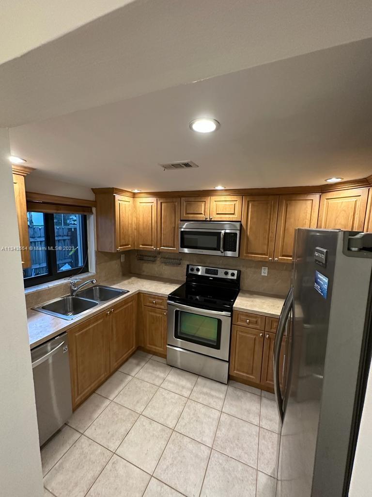 Snapper Creek Townhouses Miami, FL 33173 - Photo 6 of 22 a kitchen with stainless steel appliances granite countertop a sink and cabinets