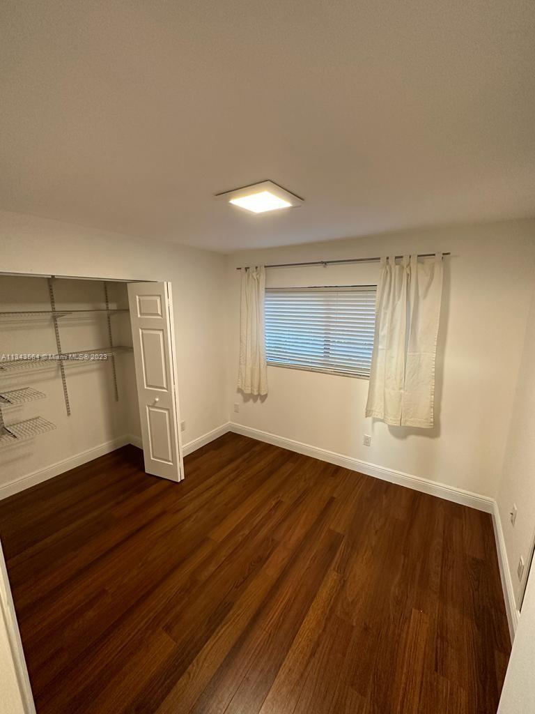 Snapper Creek Townhouses Miami, FL 33173 - Photo 9 of 22 an empty room with wooden floor closet and windows