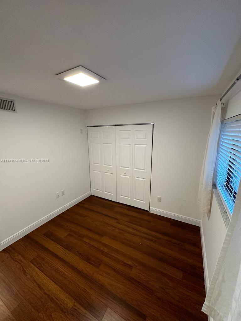 Snapper Creek Townhouses Miami, FL 33173 - Photo 10 of 22 a view of an empty room with wooden floor