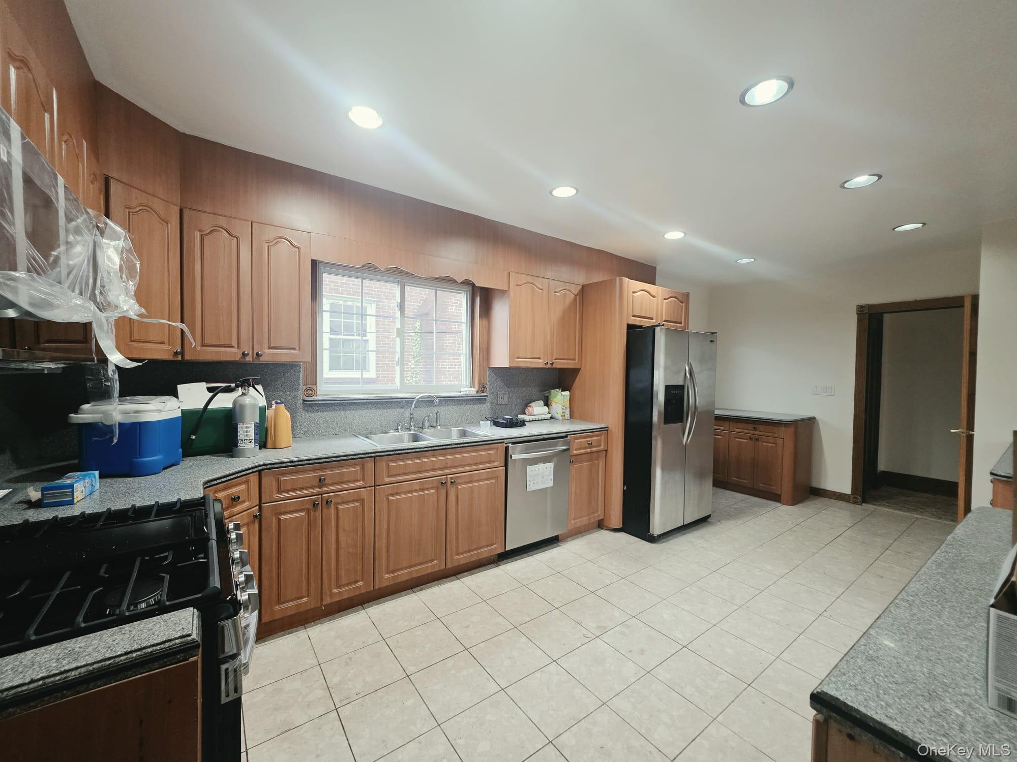 180-15 Dalny Road Queens, NY 11432 - Photo 6 of 10 a large kitchen with stainless steel appliances lots of counter space and windows