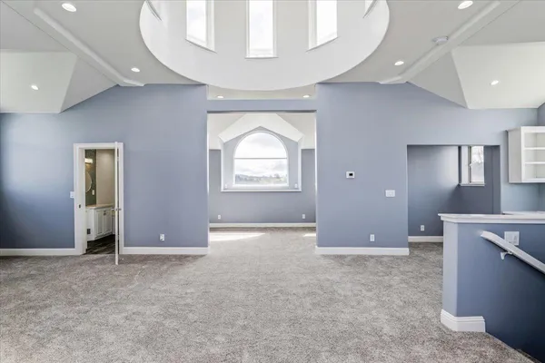 an empty room with wooden floor and a ceiling fan