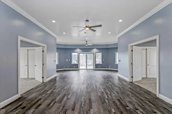 a view of a hallway with wooden floor and staircase