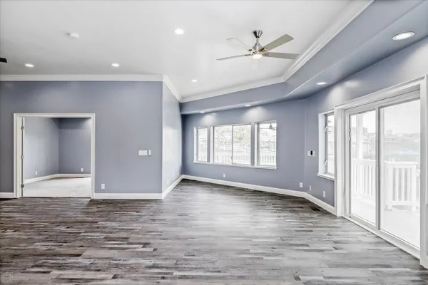 an empty room with wooden floor and a large window
