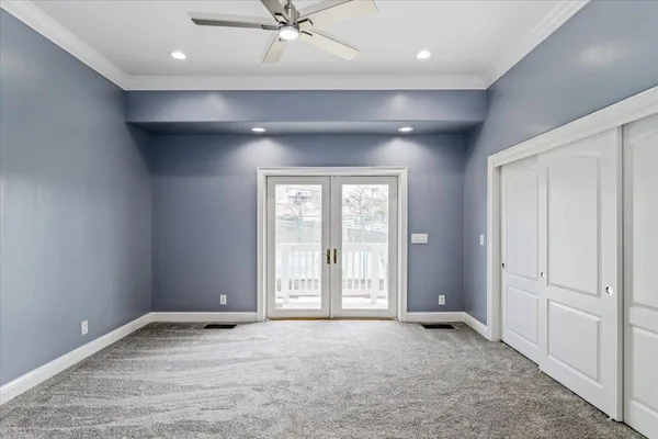 an empty room with closet and a ceiling fan