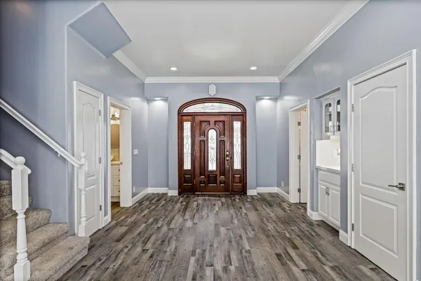 a large kitchen with kitchen island a large window a sink and stainless steel appliances