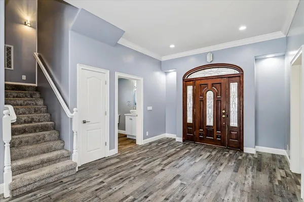 a view of a hallway with wooden floor and staircase