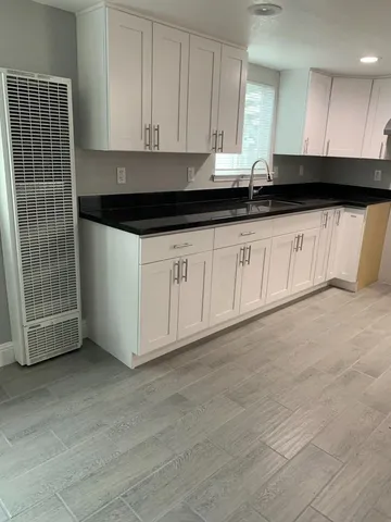 a view of kitchen with granite countertop cabinets