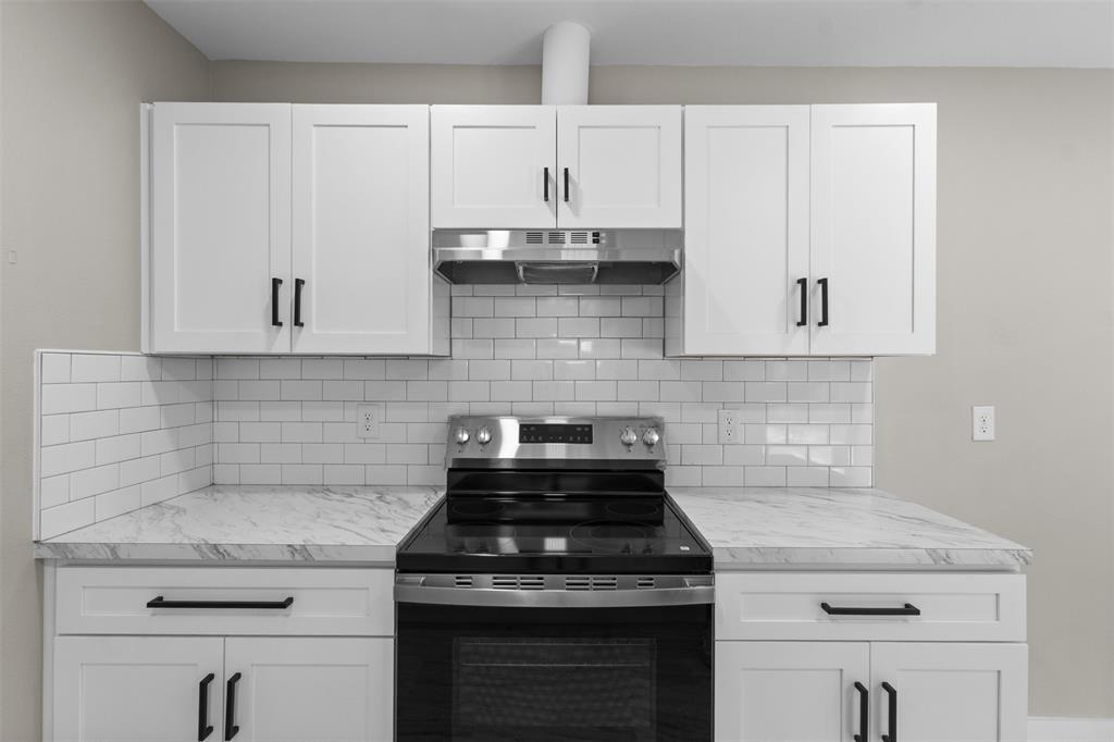 1903 Beauford Road Dallas, TX 75253 - Photo 8 of 27 White shaker-style cabinetry, subway tile backsplash, stainless steel range hood, electric range, and patterned countertops