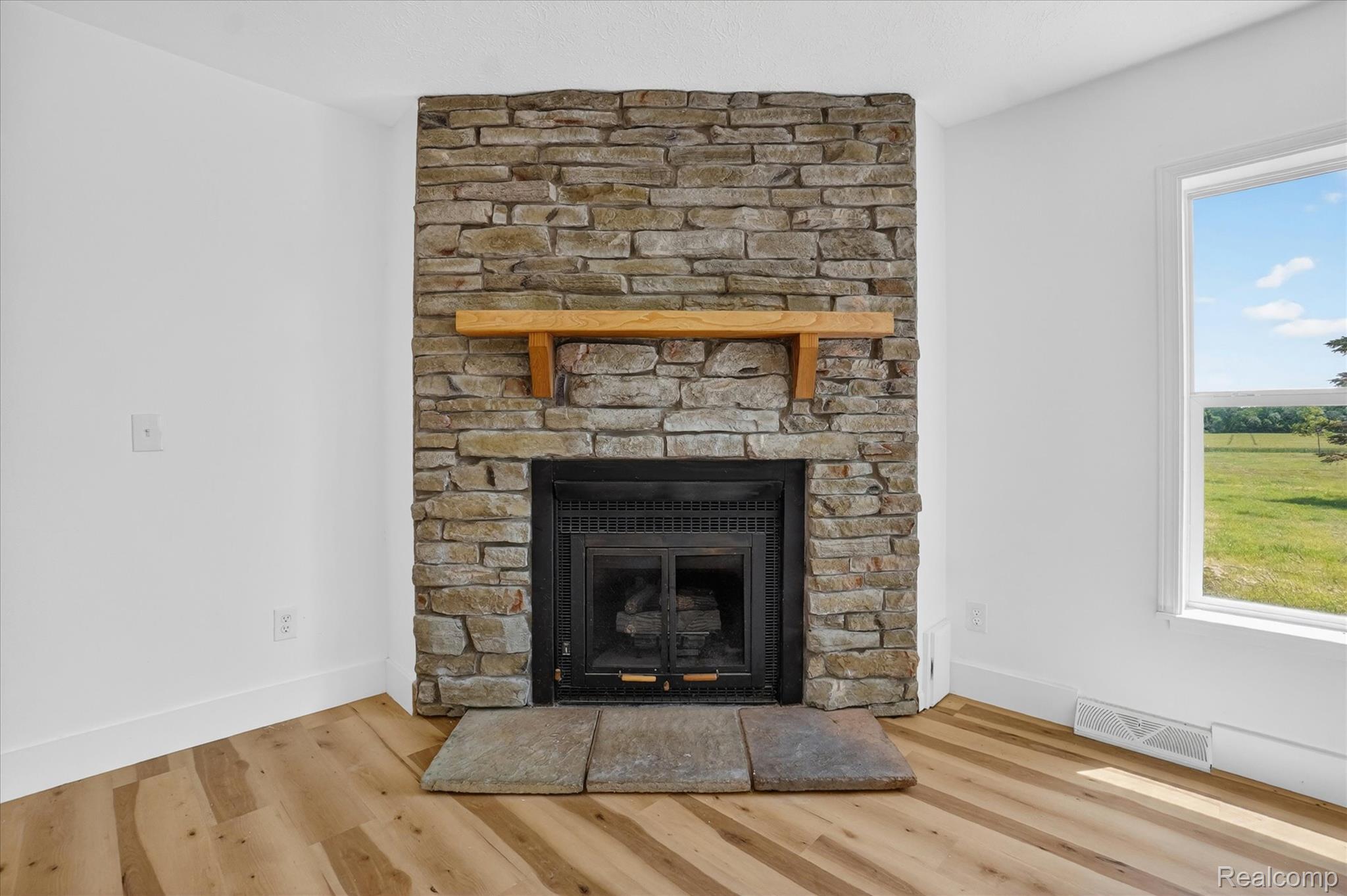 1400 North Every Road Mason, MI 48854 - Photo 5 of 33 Stacked stone fireplace featuring a wood mantel