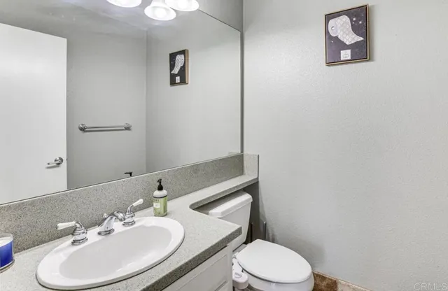 a bathroom with a sink mirror and toilet