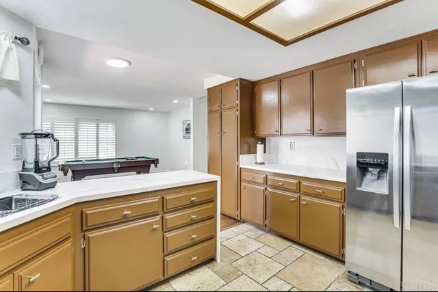 a kitchen with kitchen island a counter top space cabinets and stainless steel appliances