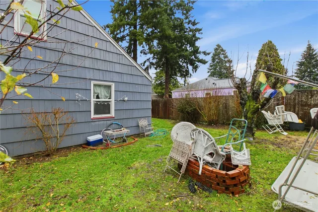a view of a chair and table in backyard of the house