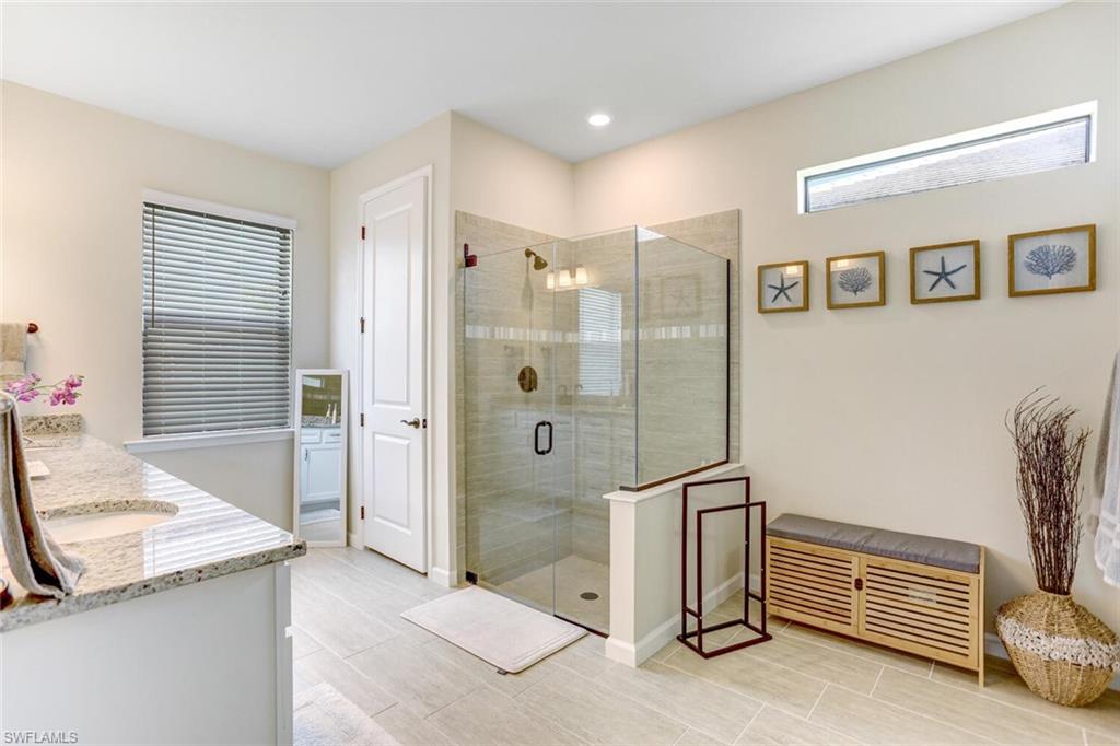 19809 Beechcrest Place Estero, FL 33928 - Photo 12 of 33 a spacious bathroom with a granite countertop sink and a mirror