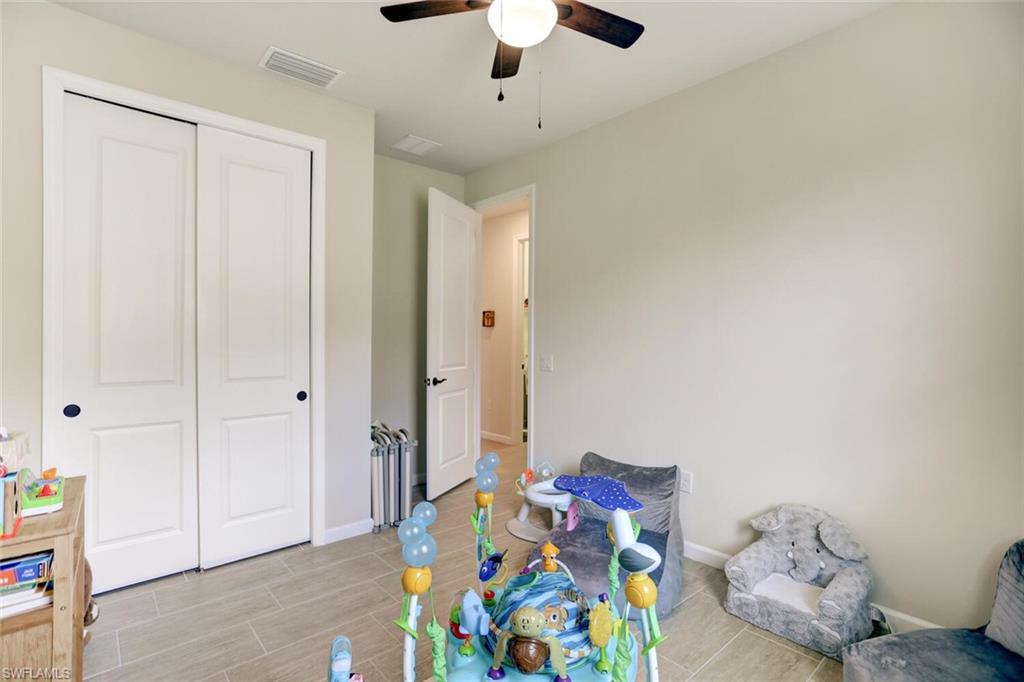 19809 Beechcrest Place Estero, FL 33928 - Photo 18 of 33 a bedroom with a bed and a chandelier