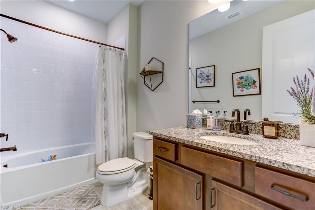 19809 Beechcrest Place Estero, FL 33928 - Photo 20 of 33 a bathroom with a granite countertop sink toilet and shower