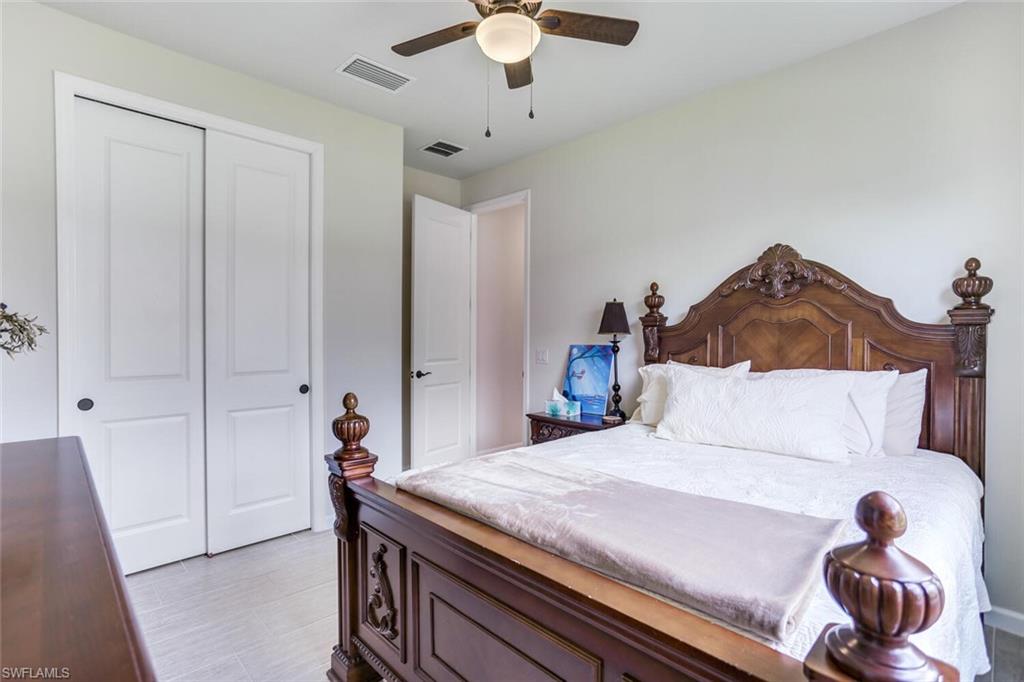 19809 Beechcrest Place Estero, FL 33928 - Photo 21 of 33 a bedroom with a bed and a chandelier