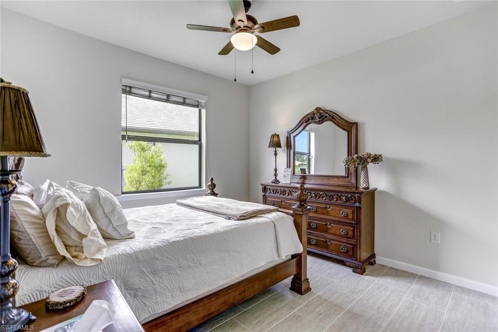 19809 Beechcrest Place Estero, FL 33928 - Photo 22 of 33 a bedroom with a bed and a chandelier