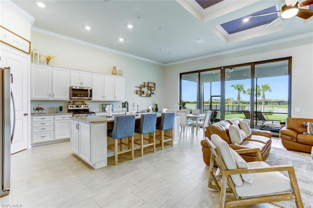 19809 Beechcrest Place Estero, FL 33928 - Photo 4 of 33 a living room with stainless steel appliances furniture a large window and a kitchen view