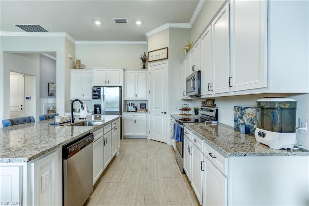 19809 Beechcrest Place Estero, FL 33928 - Photo 5 of 33 a large kitchen with stainless steel appliances granite countertop a lot of counter space and a sink