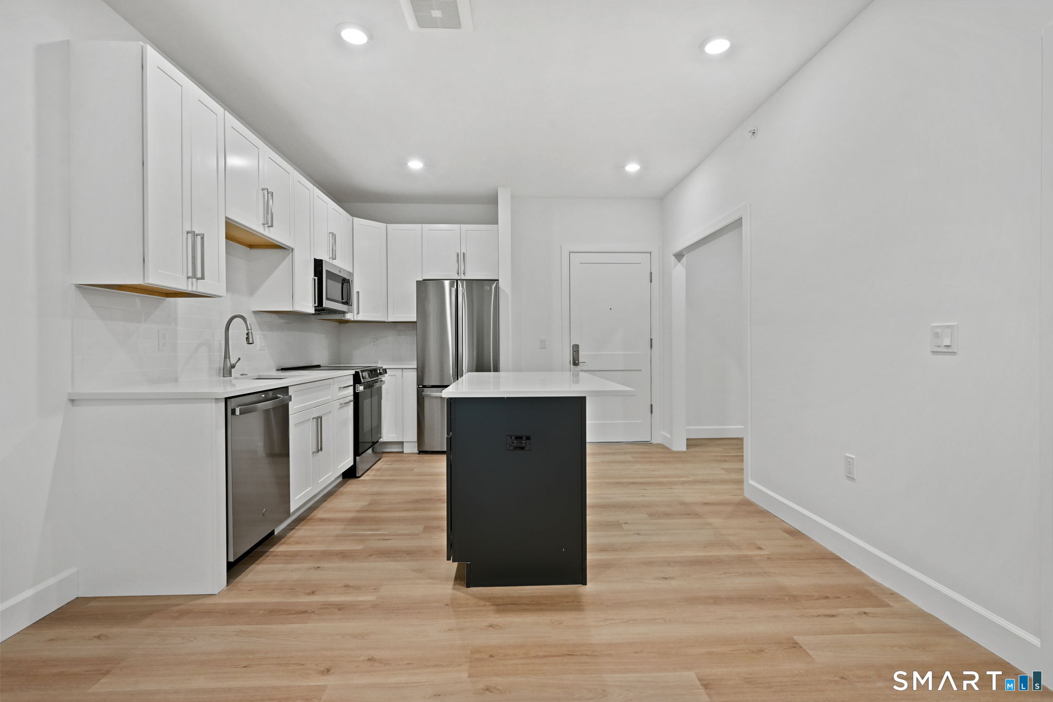 131 Beach Road, Unit 202 Fairfield, CT 06824 - Photo 13 of 32 a large kitchen with a center island and stainless steel appliances