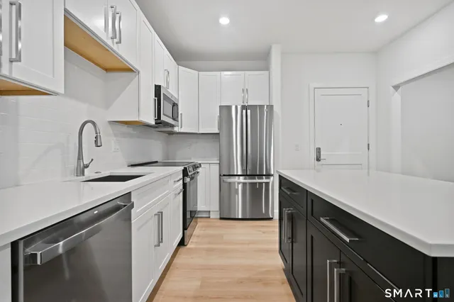 a kitchen with stainless steel appliances a sink stove and refrigerator