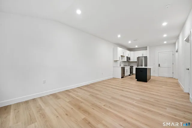 a view of kitchen with refrigerator and wooden floor