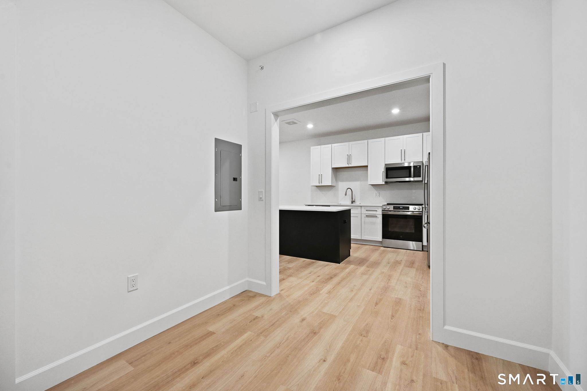 131 Beach Road, Unit 202 Fairfield, CT 06824 - Photo 21 of 32 a large white kitchen with cabinets