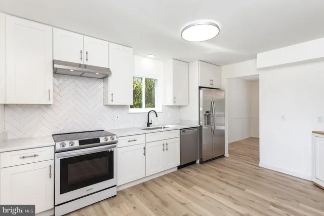 a view of a kitchen with wooden floor and electronic appliances