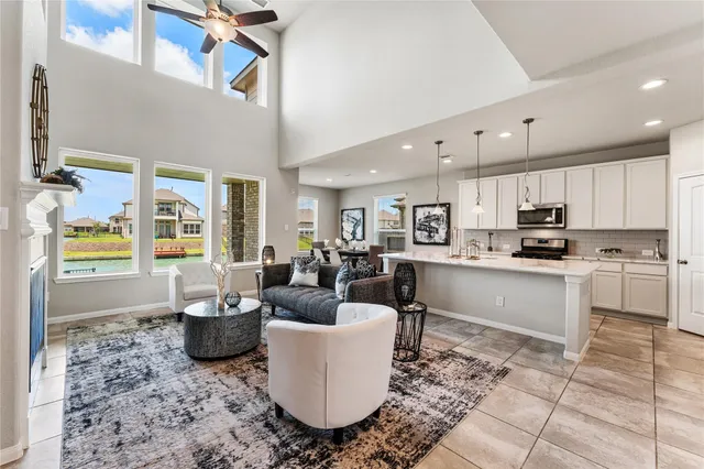 a living room with stainless steel appliances granite countertop a couch a stove a microwave a sink and cabinets
