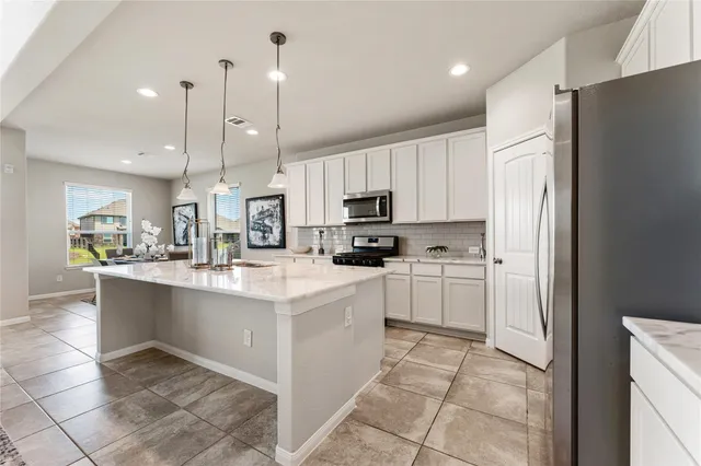 a kitchen with stainless steel appliances a refrigerator sink and microwave