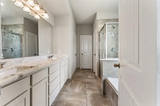 a spacious bathroom with a double vanity sink a mirror and a shower