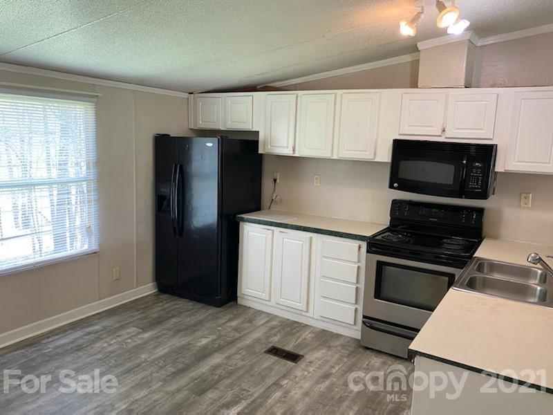 3310 Falcon Ridge Road Maiden, NC 28650 - Photo 6 of 12 a kitchen with granite countertop a refrigerator stove and microwave