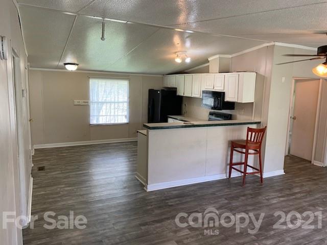 3310 Falcon Ridge Road Maiden, NC 28650 - Photo 7 of 12 a kitchen with stainless steel appliances a refrigerator a sink a stove and white cabinets with wooden floor