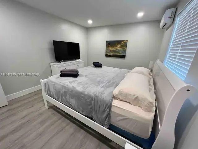 a bedroom with a bed and a flat screen tv
