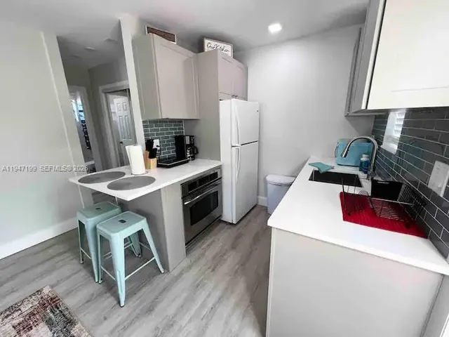 a kitchen that has a microwave a stove and a refrigerator