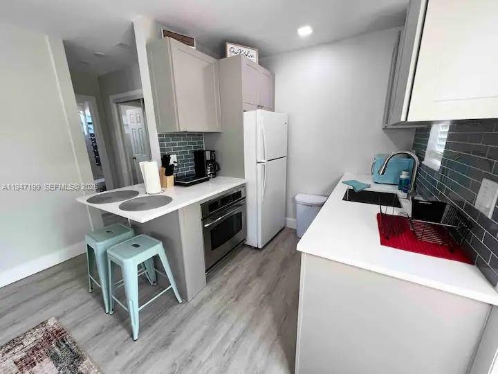 1925 Dewey Street, Unit 3 Hollywood, FL 33020 - Photo 16 of 27 a kitchen that has a microwave a stove and a refrigerator