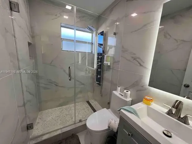 a bathroom with a sink a toilet and shower