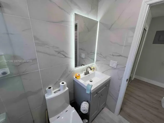 a bathroom with a toilet sink and mirror