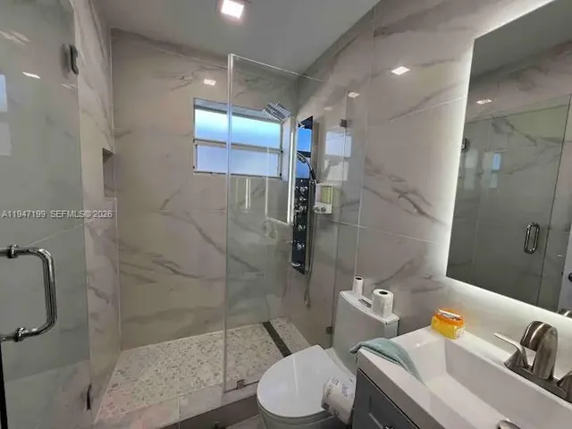 a bathroom with a sink toilet and shower