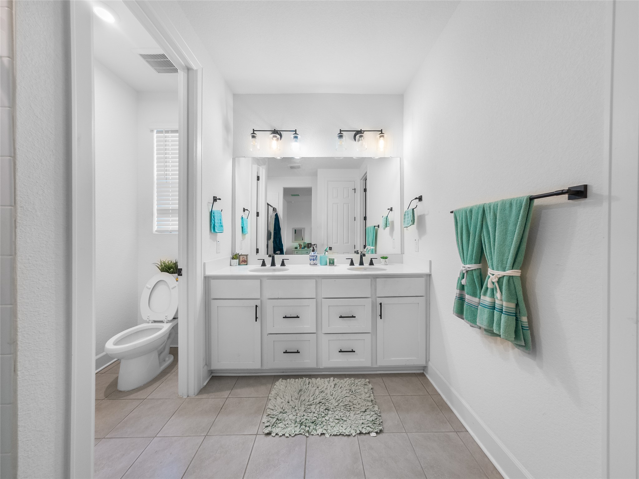 20811 Phebe Foster Street Manor, TX 78653 - Photo 19 of 40 Full bathroom with double vanity and light tile patterned flooring