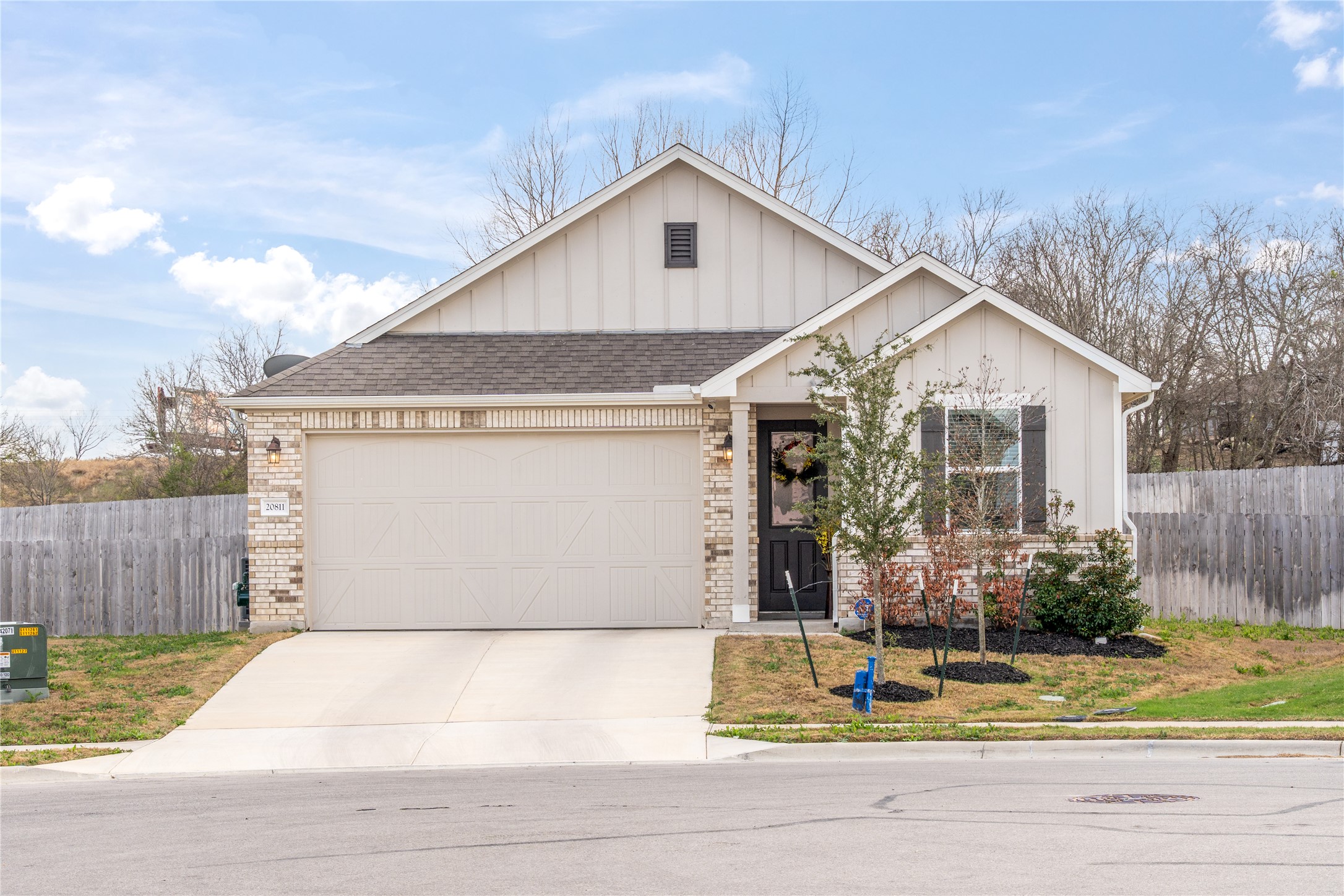 20811 Phebe Foster Street Manor, TX 78653 - Photo 2 of 40 Ranch-style home with board and batten siding, an attached garage, brick siding, and concrete driveway